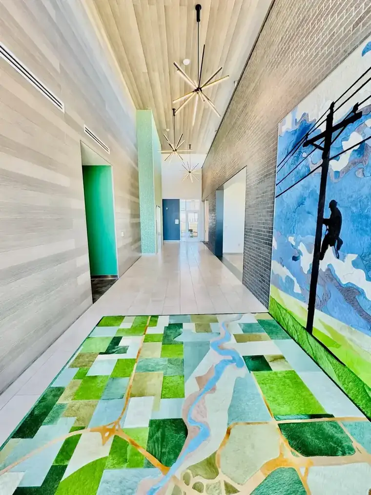 Wood slat ceiling and custom cowhide floor map in the Oklahoma Electric Cooperative entry corridor, built by Geddes-Armstrong Construction