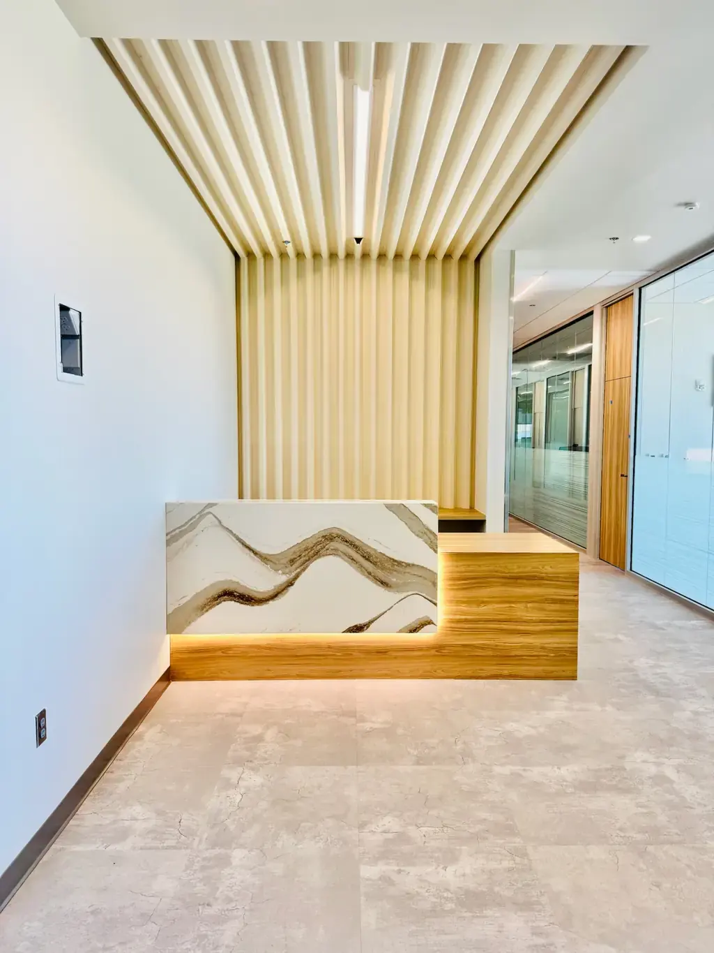 Reception area with backlit quartz and fluted timber finished by Geddes-Armstrong Construction